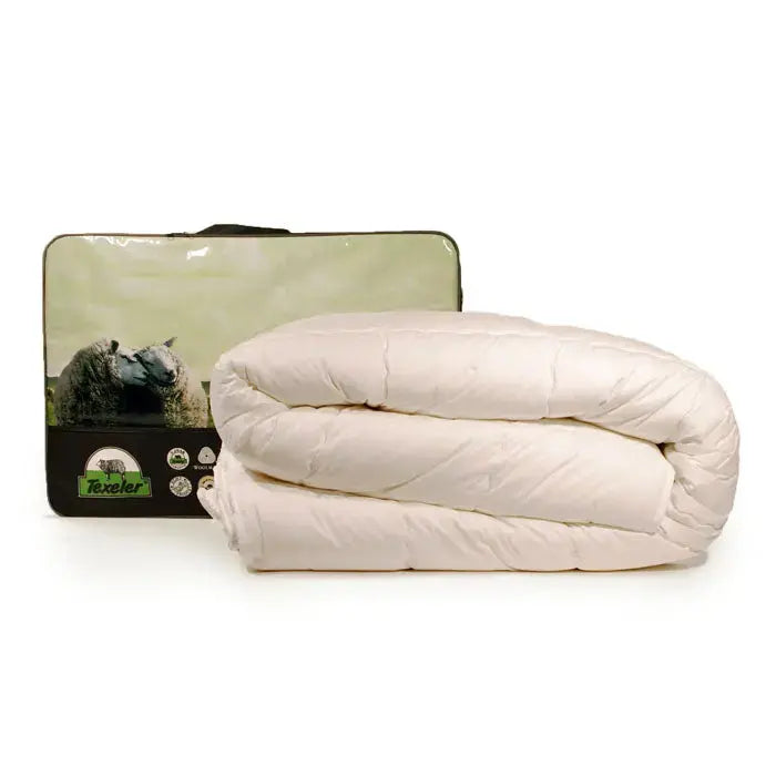 A folded beige comforter alongside its packaging, which features an image of a sheep on a green background. product name texeler pure nature perkal wool comforter.